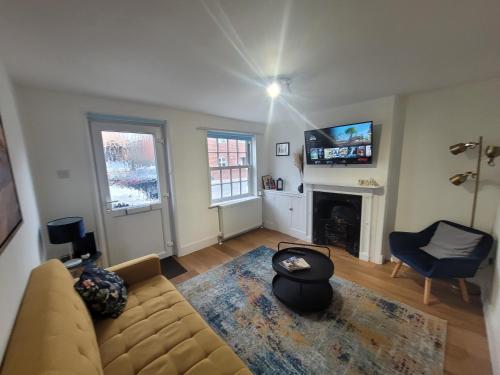 a living room with a couch and a fireplace at Little Oaks House - Historic Charm & Modern Comfort in Colchester by Catchpole Stays in Colchester