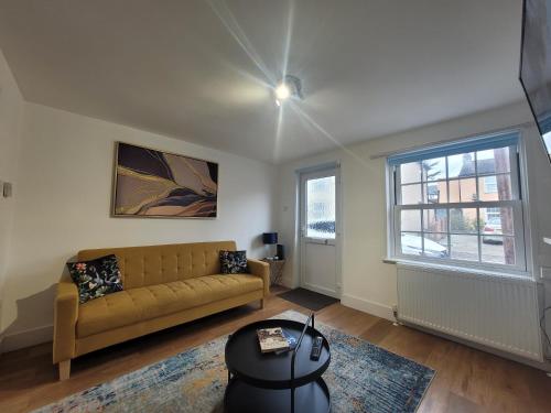 a living room with a couch and a window at Little Oaks House - Historic Charm & Modern Comfort in Colchester by Catchpole Stays in Colchester