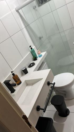 La salle de bains blanche est pourvue de toilettes et d'un miroir. dans l'établissement Condomínio morada real, à Petrolina