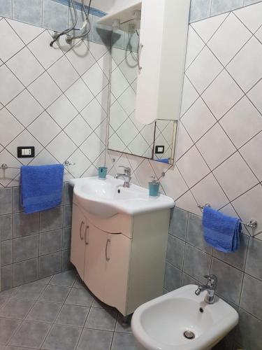 a bathroom with a sink and a toilet and a mirror at Appartamento Lido Rossello in Realmonte