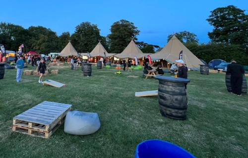 a group of tents in a grass field with people at Intents VIP Zone @ Silverstone F1 in Whittlebury