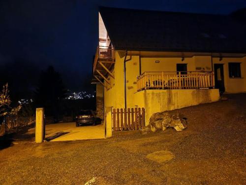 a building with a fence and a car parked next to it at Chalet côté montagne in Oz