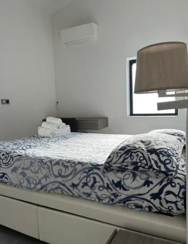 - un lit avec une couverture bleue et blanche et un miroir dans l'établissement Jardin secret en plein cœur du Cabot, à Marseille