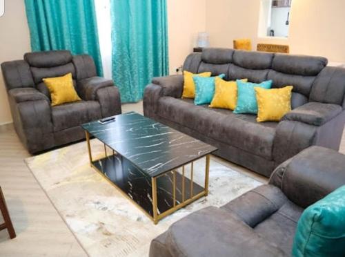 Sala de estar con 2 sofás y mesa de centro en bluesky en Nairobi