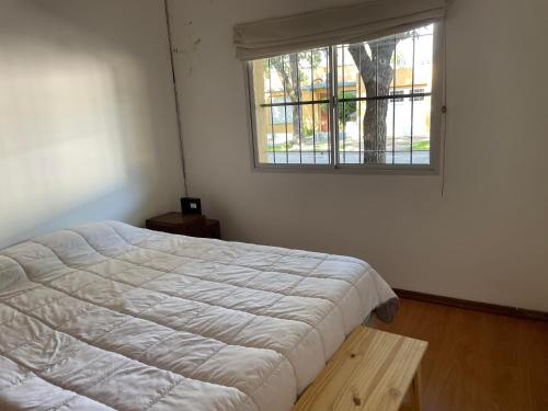 a bedroom with a white bed and a window at Dorrego in Venado Tuerto