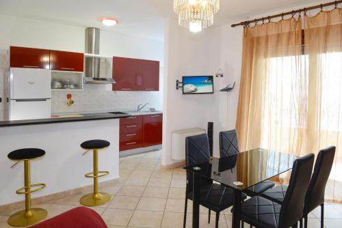 cocina con mesa de cristal y sillas negras en Casa Vacanza Il Dolce Mare, en Alghero