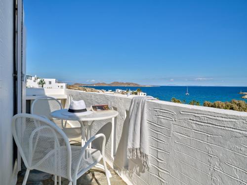 a table and chairs on a balcony with a view of the ocean at Kanale's Rooms & Suites in Naousa