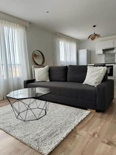 - un salon avec un canapé noir et une table en verre dans l'établissement Le 41, à Dijon