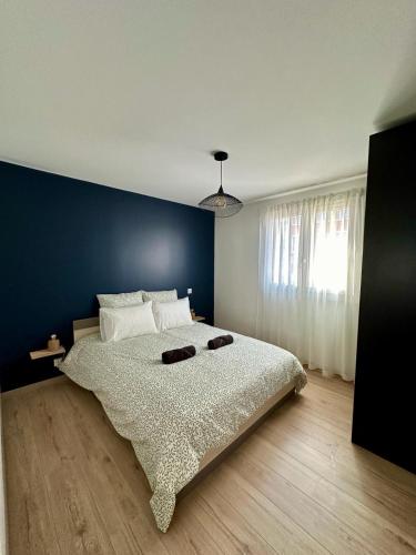 a bedroom with a large bed with a blue wall at Le 41 in Dijon