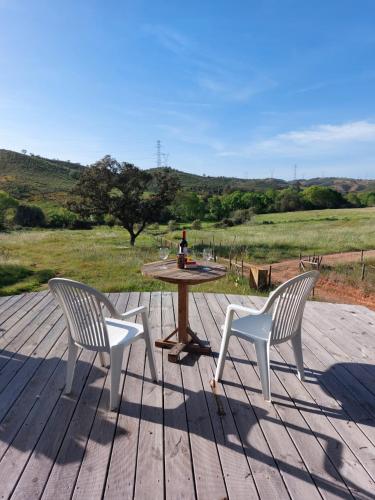two chairs and a table on a wooden deck at Lost Paradise - A night into the Alentejo! in Sabóia