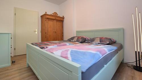 een slaapkamer met een groot bed met een houten hoofdeinde bij Georgentor in Naumburg