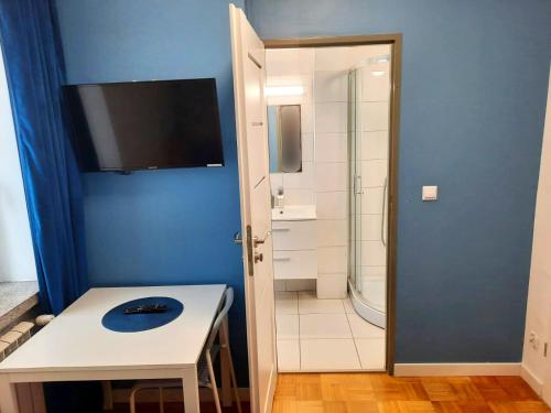a bathroom with a white table and a shower at Noclegi Centrum Chełm in Chełm