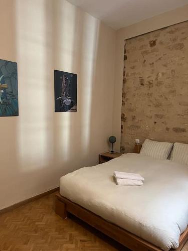 - une chambre avec un lit blanc et deux photos sur le mur dans l'établissement Le San Luis Obispo, à Montpellier