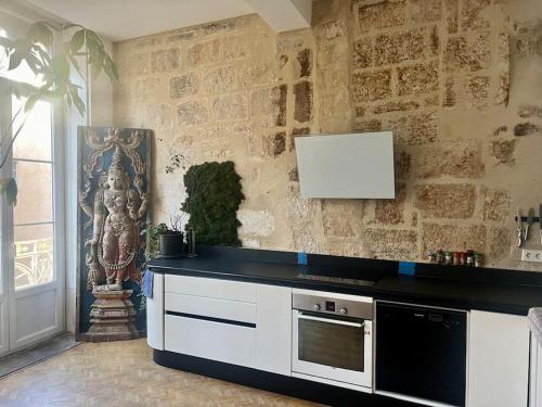 - une cuisine avec un comptoir noir et une cuisinière dans l'établissement Le San Luis Obispo, à Montpellier