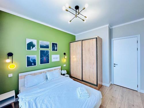 1 dormitorio con 1 cama grande y paredes verdes en Grand Turan Business 2-Room Apartament's en Astaná