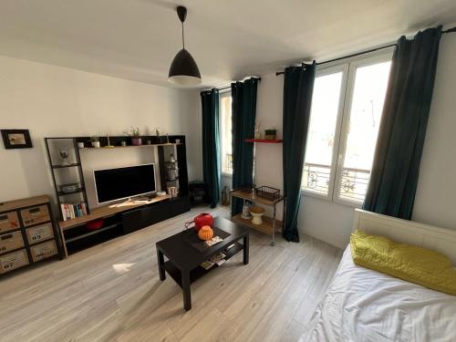 a living room with a tv and a teddy bear on a table at Appartement paisible in Clichy