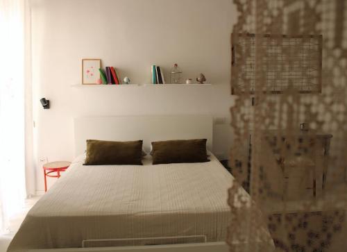een slaapkamer met een wit bed met 2 kussens bij Casa Vittoria Martina Franca in Martina Franca