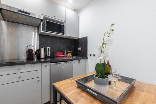 - une cuisine avec une table et une plante en pot dans l'établissement 1 Bdr Large Terrace, à Nice