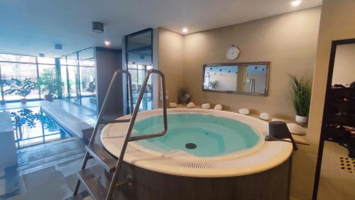 a large bathroom with a tub with a swimming pool at Heart and Soul Apartment in Budapest