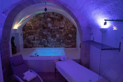 La salle de bains est pourvue d'une baignoire et d'un éclairage violet. dans l'établissement Loft 900 - Home & SPA - A Timeless Luxury in Monopoli, à Monopoli