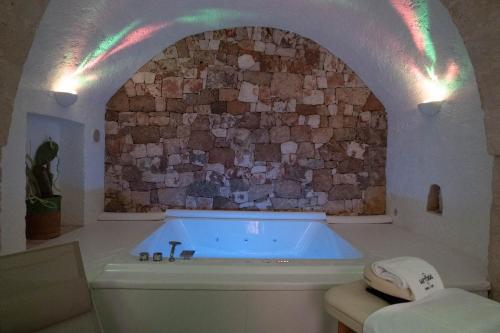 a bath tub in a room with a stone wall at Loft 900 - Home & SPA - A Timeless Luxury in Monopoli in Monopoli