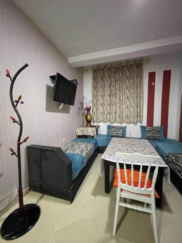1 dormitorio con cama, mesa y sofá en Coin de repôs en Oujda