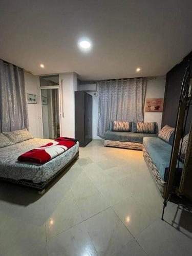 1 dormitorio con 2 camas y sofá en Coin de repôs, en Oujda