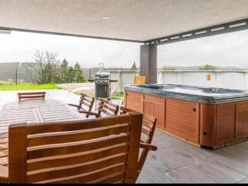 a large hot tub on a patio with benches at Vila Frigo Olimia in Podplat