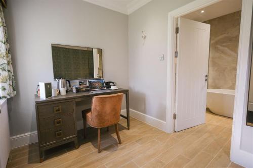 a desk with a mirror and a chair in a room at Mulberry House in Ongar