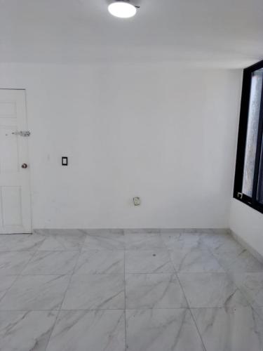 グアダラハラにあるDepa patria y vallartaの白い壁と白いタイルフロアの空き部屋