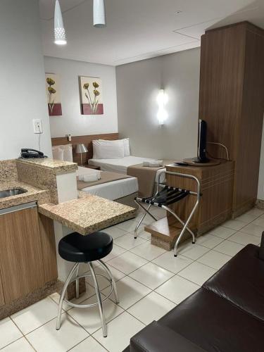 a room with a kitchen and a living room at Sun Square Suítes Hotel By Lual in Goiânia