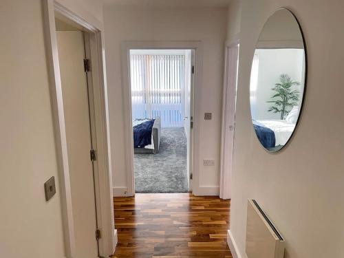 einen Flur mit einem Spiegel und ein Zimmer mit einem Bett in der Unterkunft Manchester's Prime - Luxurious 1-Bed Flat in Manchester