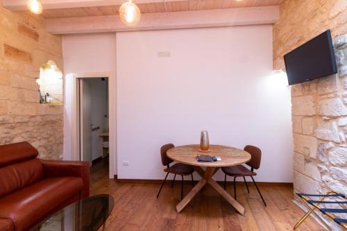 a living room with a table and a couch at Le Nicchie luxury rooms in Lecce