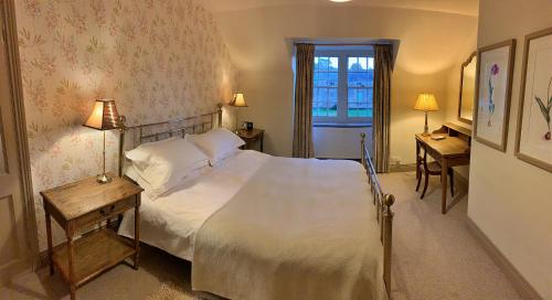 une chambre avec un lit et deux tables et une fenêtre dans l'établissement Finest Retreats - Ingleby Manor - Courtyard Cottage, à Great Ayton