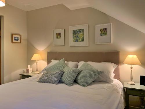 a bedroom with a white bed with three pillows at Finest Retreats - Ingleby Manor - Manor Cottage in Great Ayton