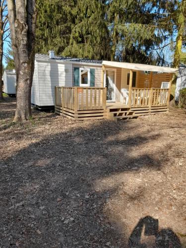 une cabane avec une véranda et un arbre dans l'établissement Le C24 - Charmant bungalow tout équipé pour 4 avec TV, à Boofzheim