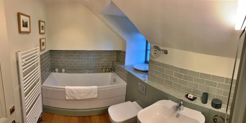 a bathroom with a bath tub and a sink at Finest Retreats - Ingleby Manor - Manor Cottage in Great Ayton