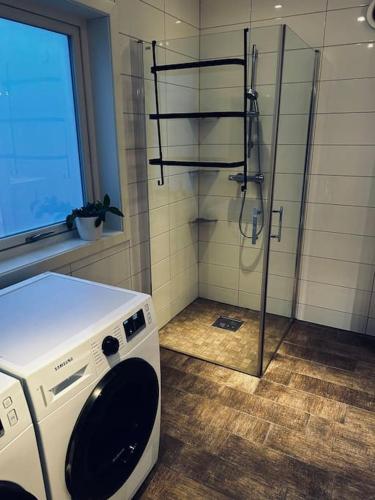 a washing machine in a bathroom with a shower at Moderne rekkehus, god standard. in Ålesund