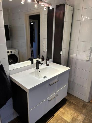 a white bathroom with a sink and a mirror at Moderne rekkehus, god standard. in Ålesund