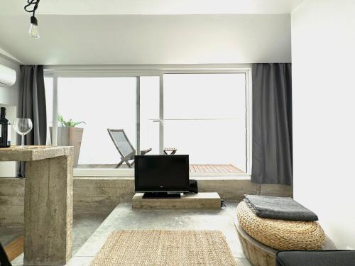 a living room with a tv and a large window at Casa Pátio Boa Vista 4 in Setúbal