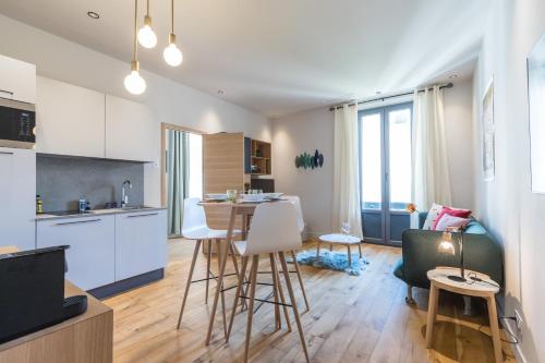 une cuisine et un salon avec une table et des chaises dans l'établissement Refined & Cozy 1 Bedroom Downtown, à Nice