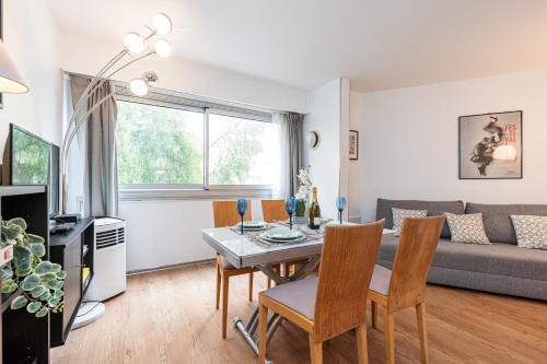 un salon avec une table, des chaises et un canapé dans l'établissement Central 1 Bdr, à Nice