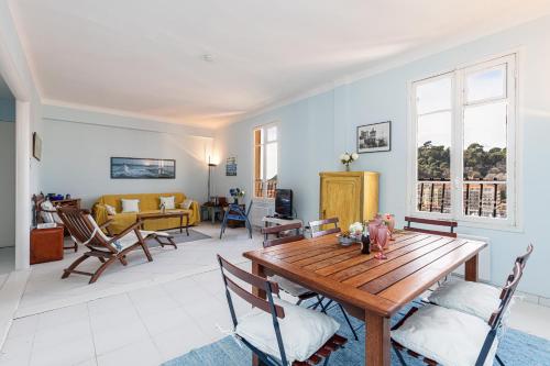 un salon avec une table et des chaises en bois dans l'établissement Extraordinary View on Port and Castle Hill - 1 Bdr & Parking, à Nice
