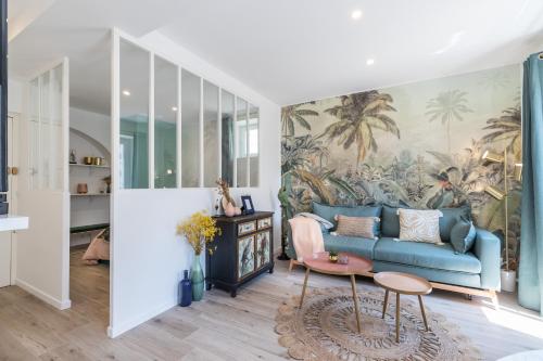 uma sala de estar com um sofá azul e um mural de palma em Lovely Apartment City Center Heart - AC em Nice