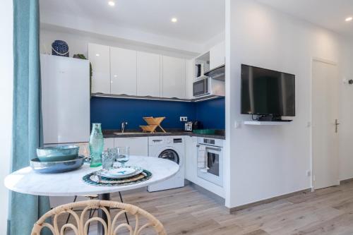 une cuisine avec un réfrigérateur blanc et une table dans l'établissement Lovely Apartment City Center Heart - AC, à Nice