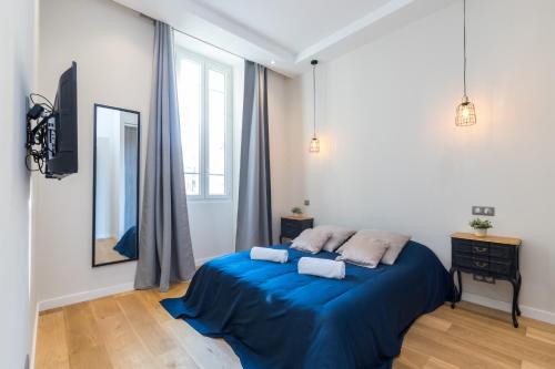 une chambre avec un lit avec des draps bleus et un miroir dans l'établissement Brand New 1 Bdr Place du Pin, à Nice