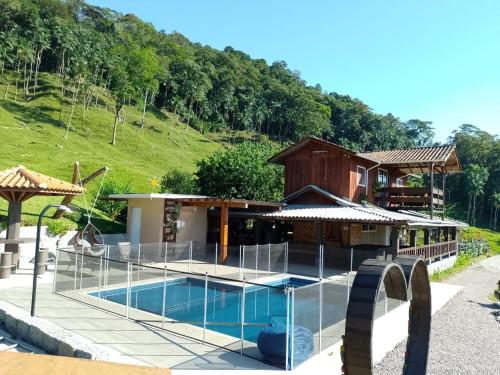 uma villa com uma piscina e uma casa em Sítio Jz em Antônio Carlos