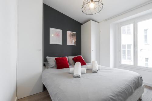 une chambre avec un grand lit blanc avec des oreillers rouges dans l'établissement Magenta Square Central 1 Bdr with AC, à Nice