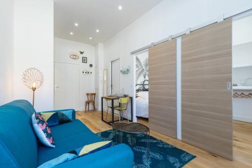 een woonkamer met een blauwe bank en een schuifdeur bij Cosy 1 Bdr Place Garibaldi & Place du Pin in Nice