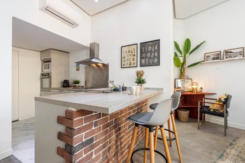uma cozinha com um balcão de tijolos e bancos em Cosy Studio in the Old Town near Garibaldi Square em Nice